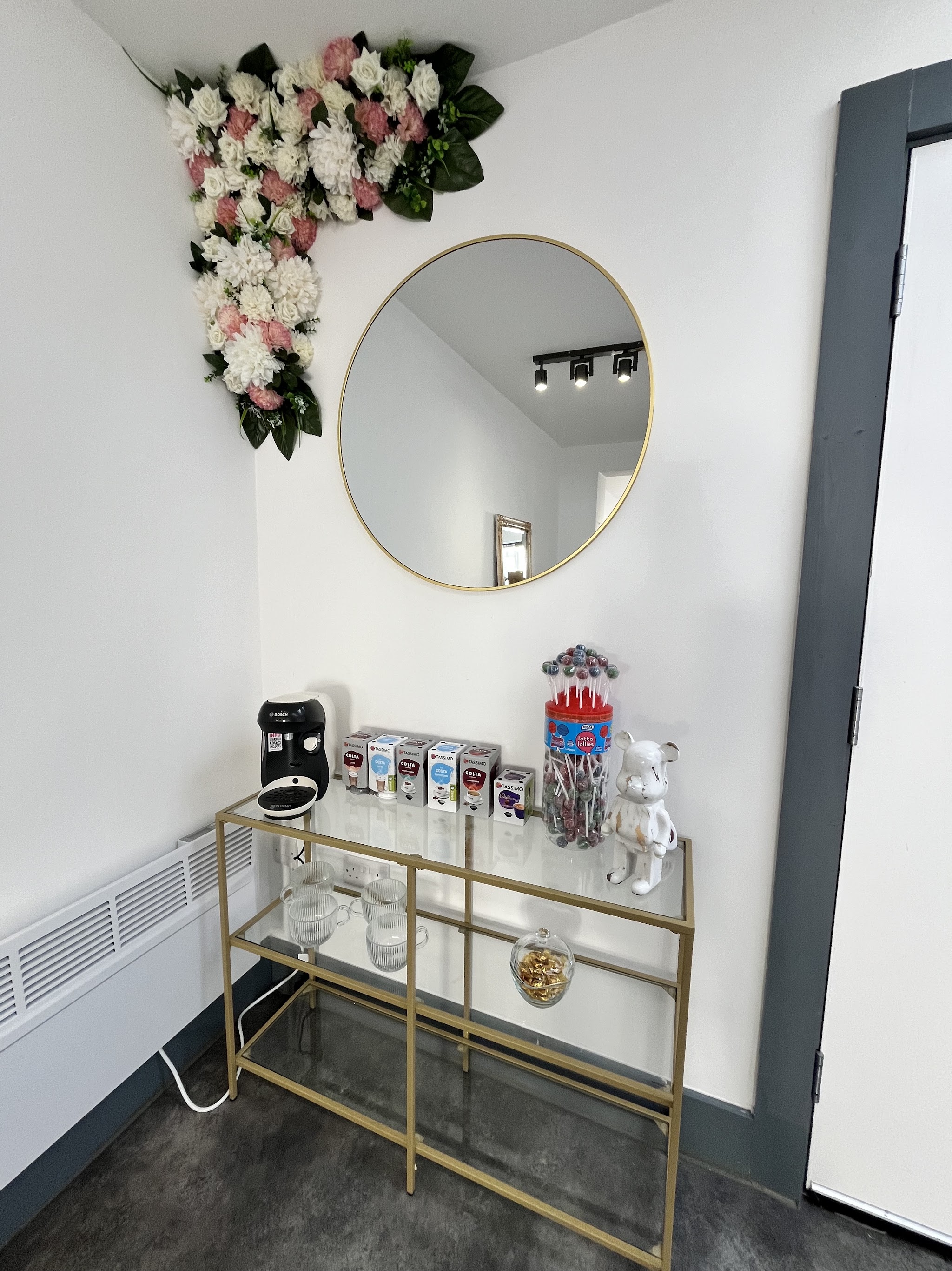 Refreshment corner with a round gold mirror and a flower garland